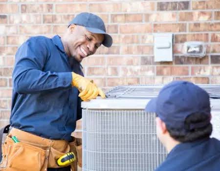 Two service technicians inspecting an outdoor air conditioning unit