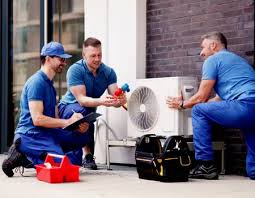 Three technicians inspecting a mini-split outdoor unit together